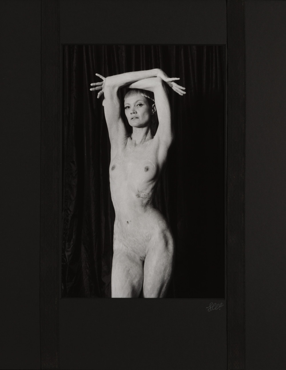 Jessica White I by Johnny Welch. A nude woman with her hands above her head covered in white body paint
