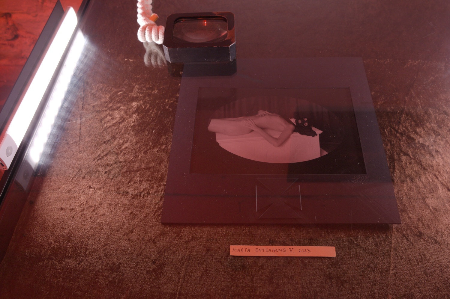 Installation view from photographic art exhibition at Pandora Art Gallery, Berlin, Germany. Photograph Marta Entsagung V in a museum-type display alongside a magnifying glass