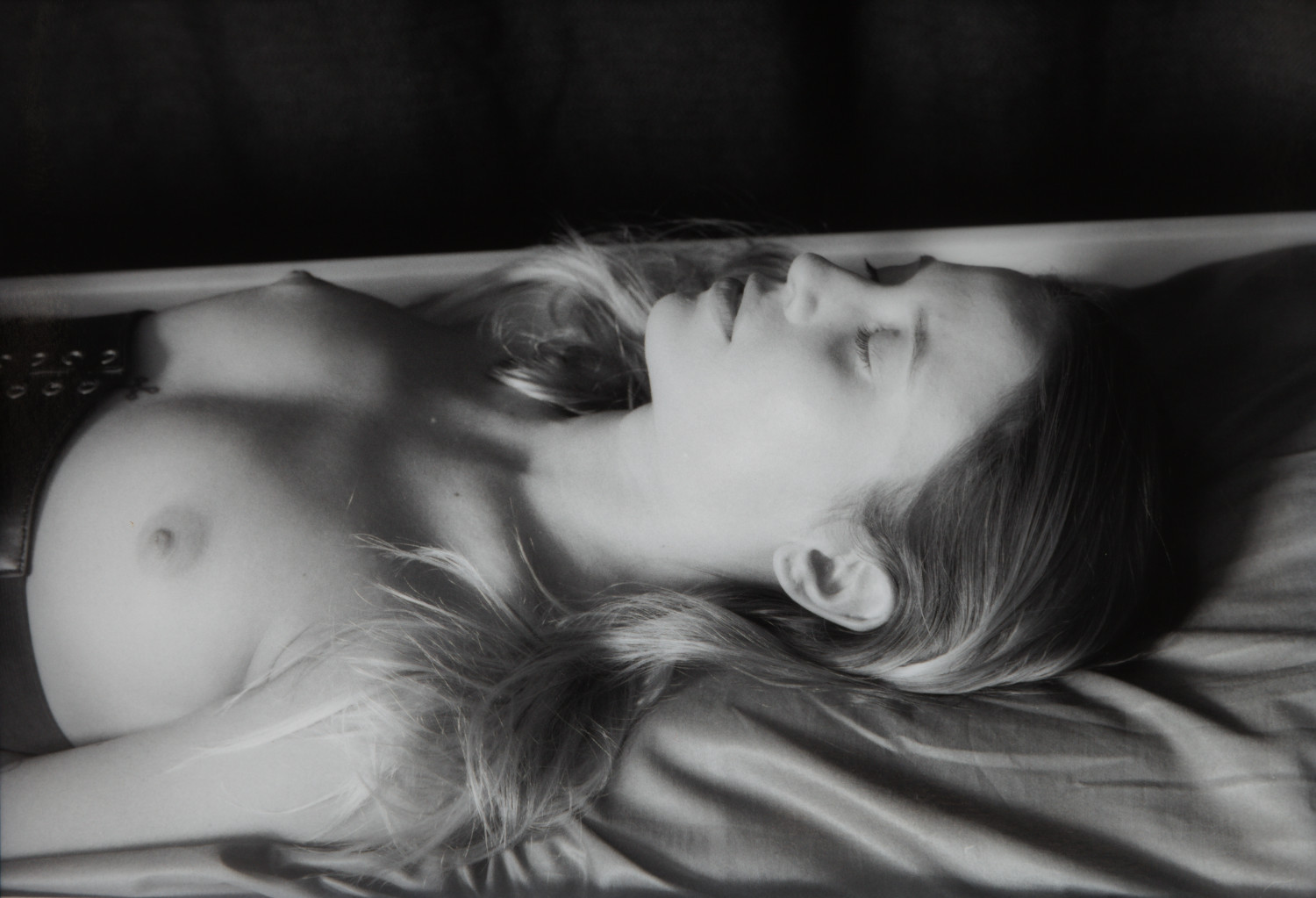 Carlotta Dornröschen V by Johnny Welch. Photograph of a semi-nude woman asleep wearing a leather corset
