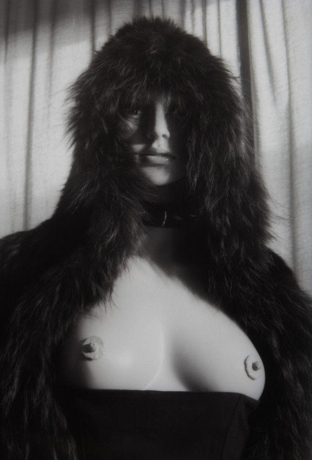 Mannequin Brat II by Johnny Welch. Photograph of a semi nude mannequin wearing a fur hood and leather choker.